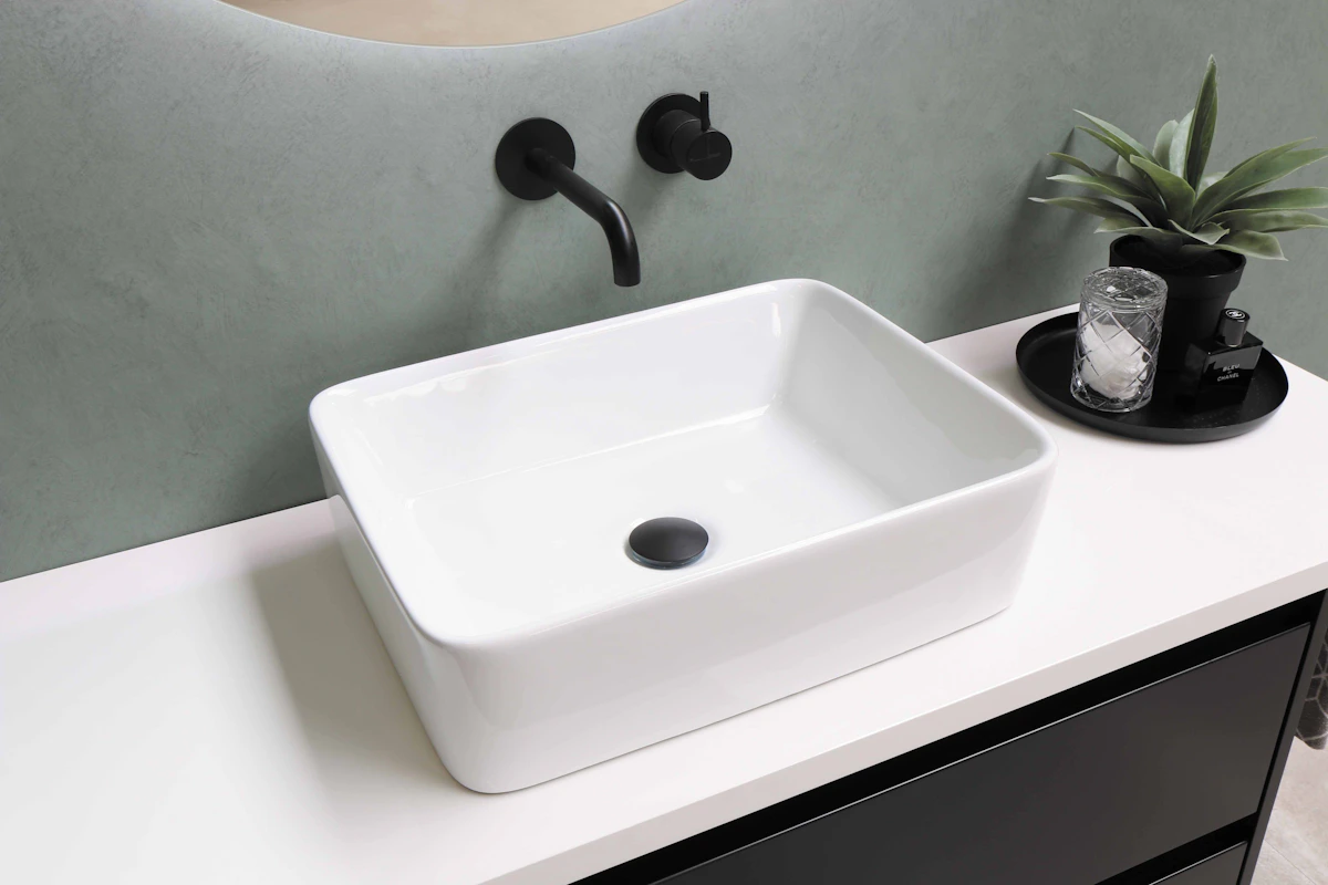White bathroom basin with black wall-mounted tapware